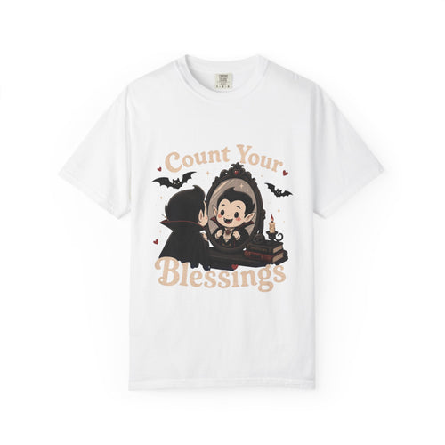 A white short-sleeve crewneck t-shirt featuring a cute cartoon graphic of a vampire smiling at mirror, with the text 'Count Your Blessings' in a peach-colored font.