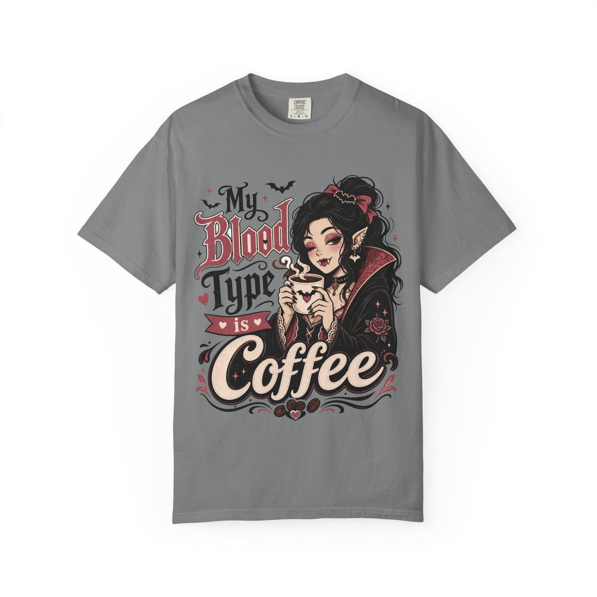 A gray short-sleeve crewneck t-shirt featuring a gothic-style graphic print of a vampire woman and the text 'My Blood Type is Coffee' in stylized red and beige lettering.
