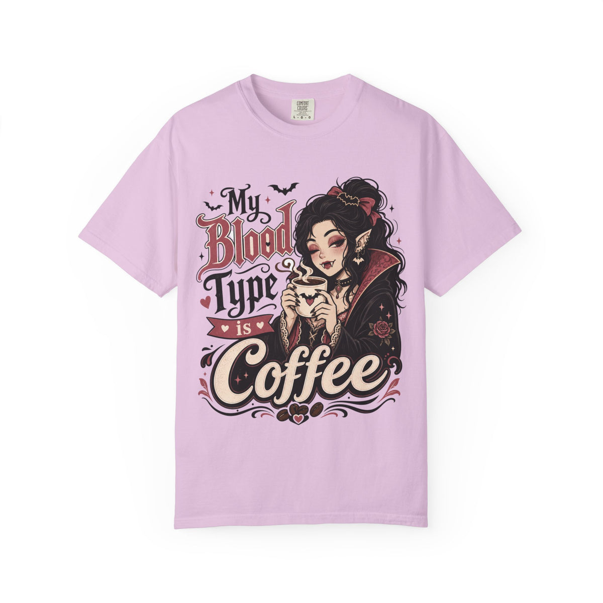 A light purple short-sleeve crewneck t-shirt featuring a gothic-style graphic print of a vampire woman and the text 'My Blood Type is Coffee' in stylized red and beige lettering.