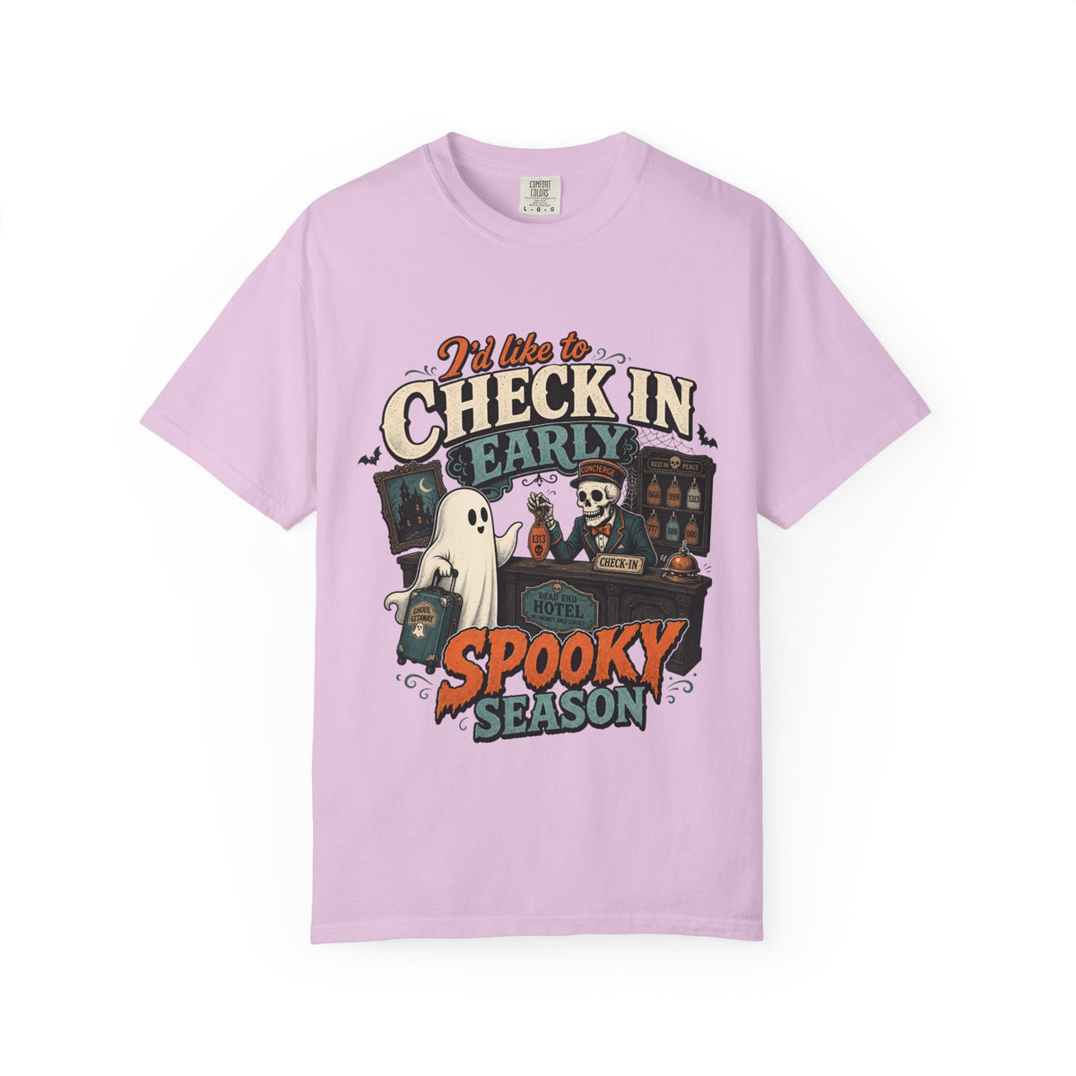 A light purple short-sleeve crewneck t-shirt featuring a colorful graphic print on the front with the text 'I'd like to CHECK IN EARLY SPOOKY SEASON' and illustrations of a skeleton concierge, a ghost, and a haunted house.