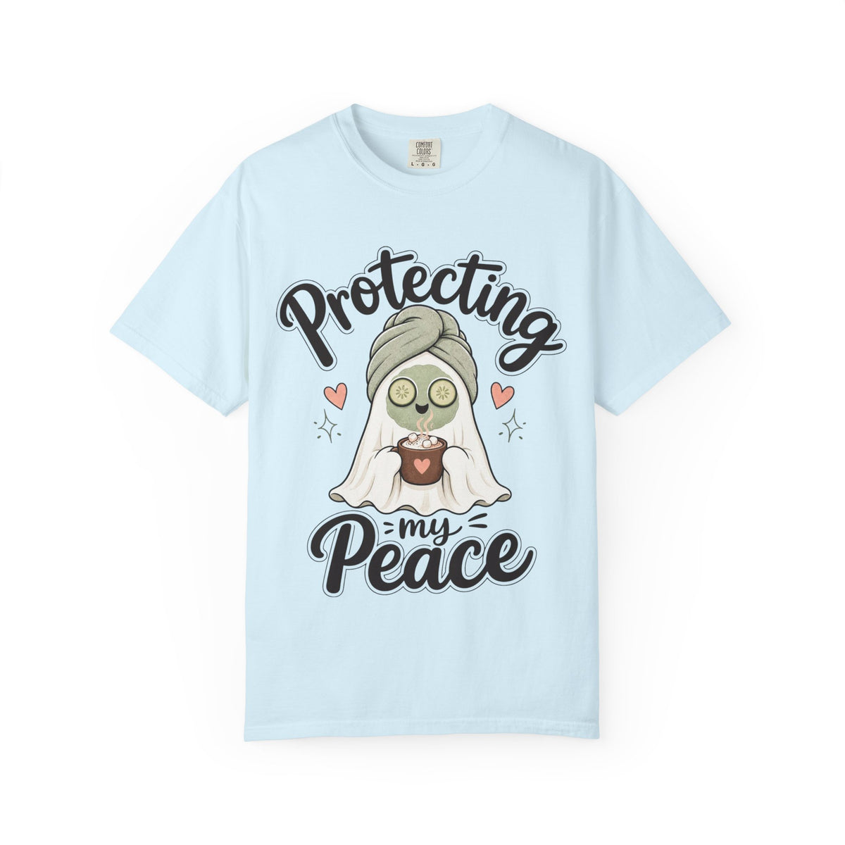 A light blue short-sleeve crewneck t-shirt featuring a graphic of a cartoon ghost wearing a green head wrap, spa mask and holding a cup, with the text 'Protecting my Peace' written in black script.