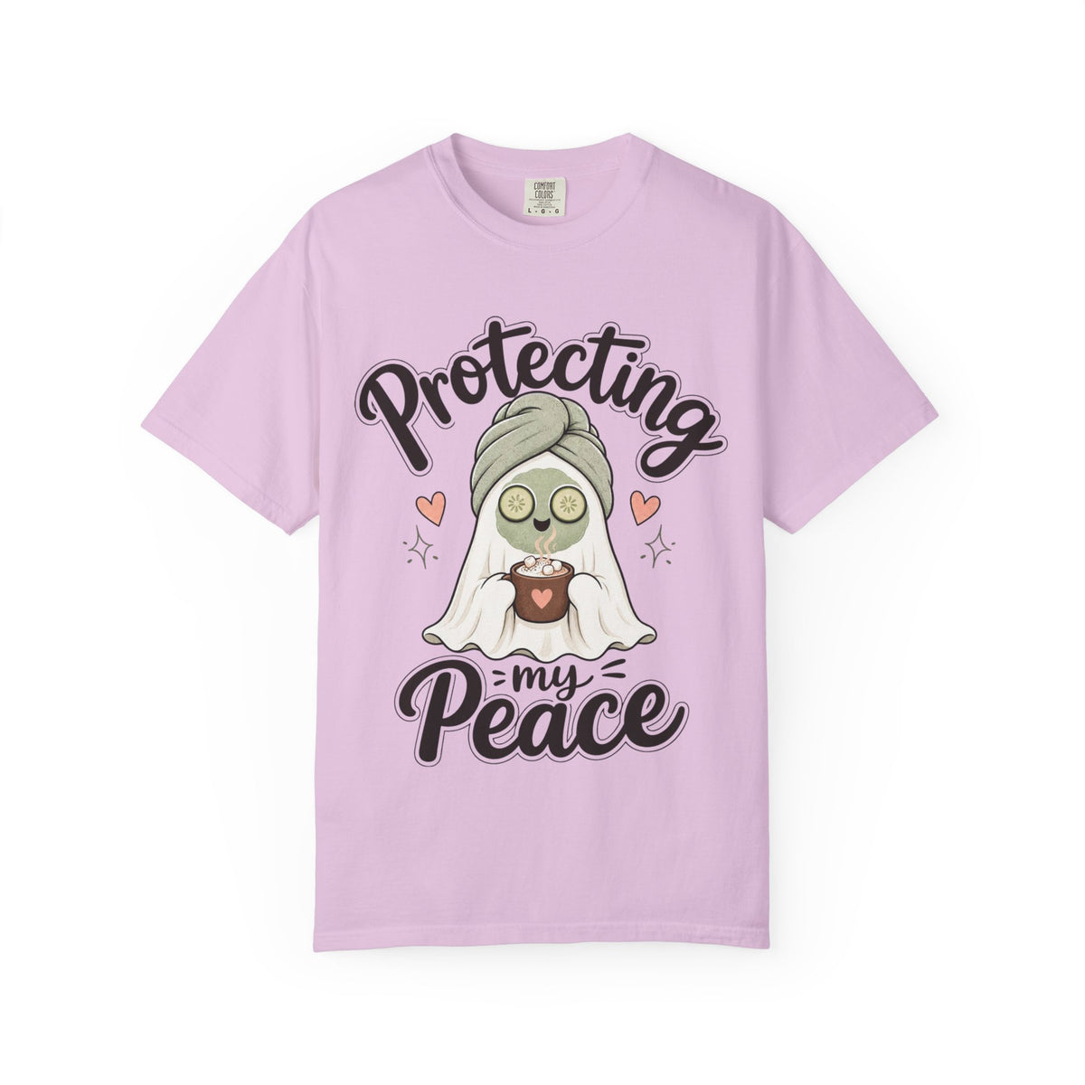 A light purple short-sleeve crewneck t-shirt featuring a graphic of a cartoon ghost wearing a green head wrap, spa mask and holding a cup, with the text 'Protecting my Peace' written in black script.