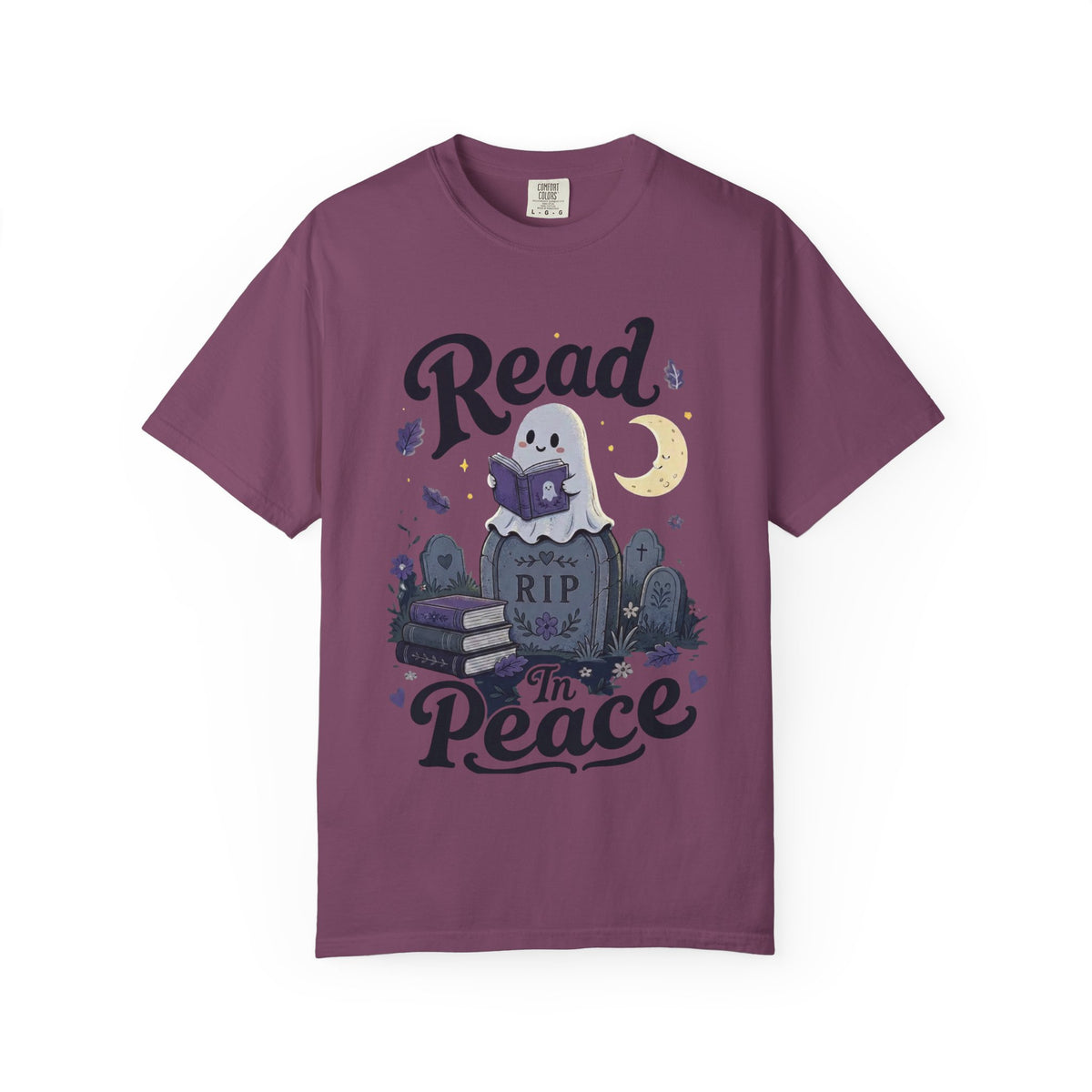 A dark purple short-sleeve crewneck t-shirt featuring a cute Halloween graphic of a ghost reading a book on top of a tombstone that says 'RIP', with the words 'Read In Peace' written in stylized lettering.