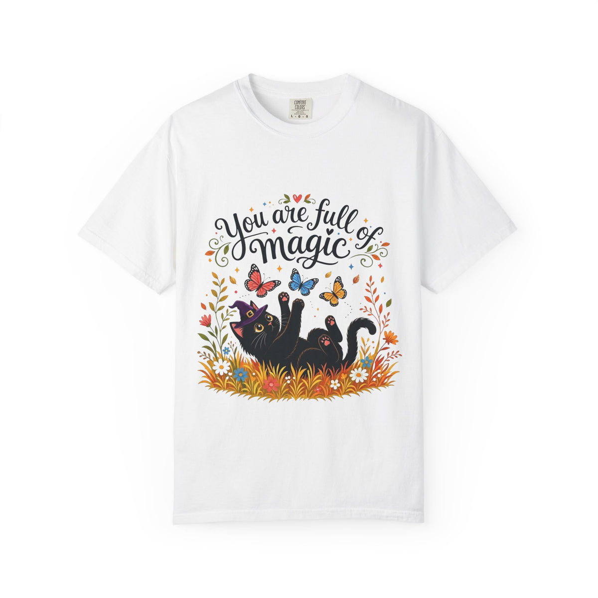 A white short-sleeve crewneck t-shirt featuring a colorful graphic print on the front. The design includes the text 'You are full of magic' in a black script font, above an illustration of a black cat surrounded by colorful butterflies, flowers, and grass.