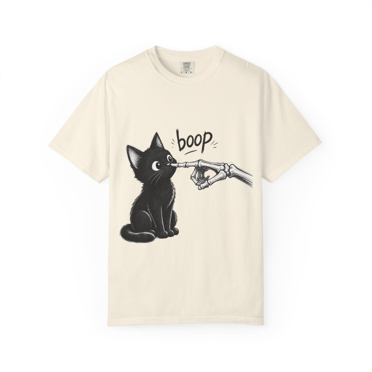 A cream short-sleeve crewneck t-shirt featuring a black graphic of a black cat being tapped by a skeletal hand with the word 'boop' written above, displayed on a clean cream background.