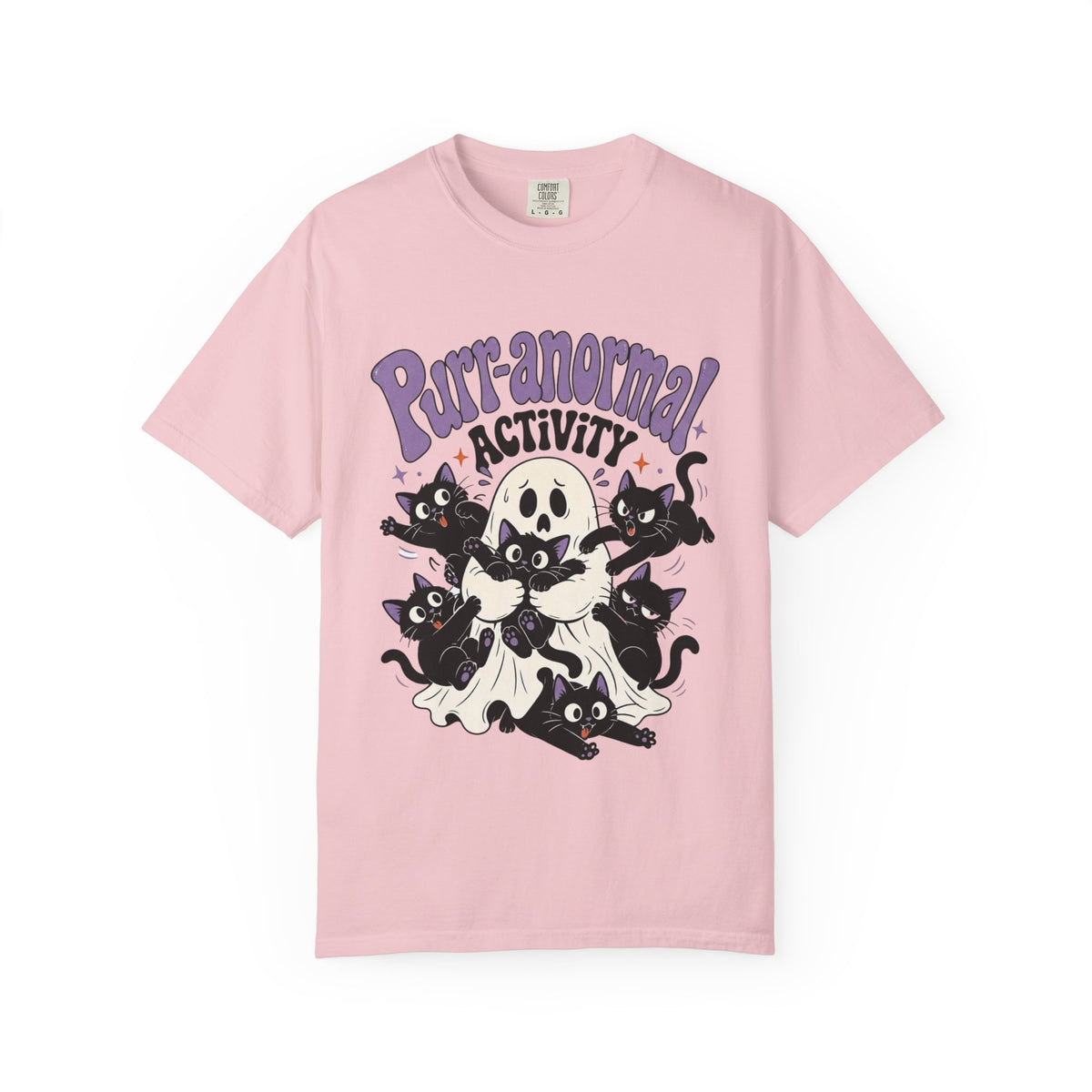 A light pink short-sleeve crewneck t-shirt featuring a cartoon graphic of black cats, a skull, and a ghost with the text 'Purr-anormal! ACTIVITY' in purple and black.