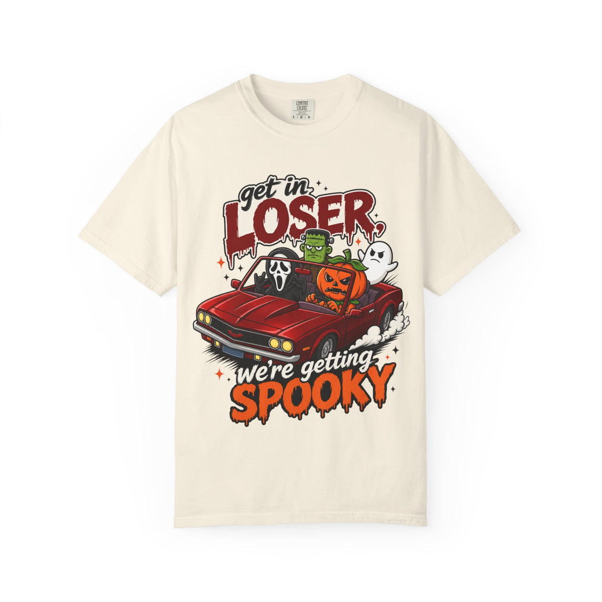 An off-white short-sleeve crewneck t-shirt featuring a colorful Halloween graphic on the front showing a red convertible car with ghosts, a pumpkin, and Frankenstein, with the text 'Get in LOSER, we're getting SPOOKY'.
