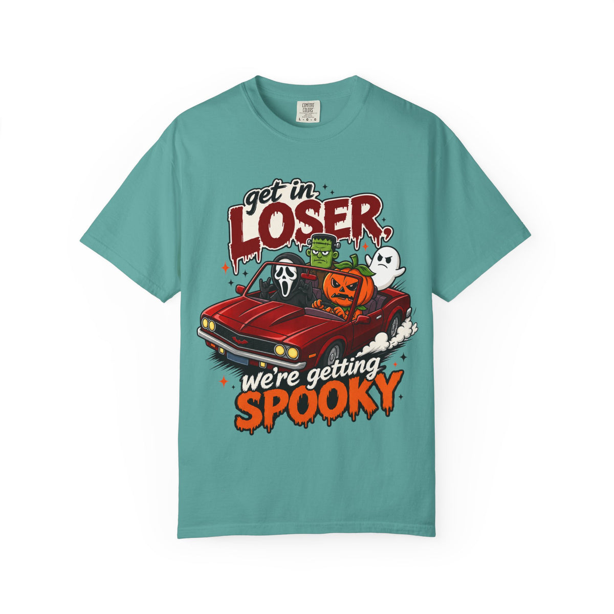 A teal short-sleeve crewneck t-shirt featuring a colorful Halloween graphic on the front showing a red convertible car with ghosts, a pumpkin, and Frankenstein, with the text 'Get in LOSER, we're getting SPOOKY'.