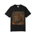 A black short-sleeve crewneck t-shirt featuring a detailed graphic print of 'The Peculiar Witch Bakery' on the front, displayed against a clean white background.