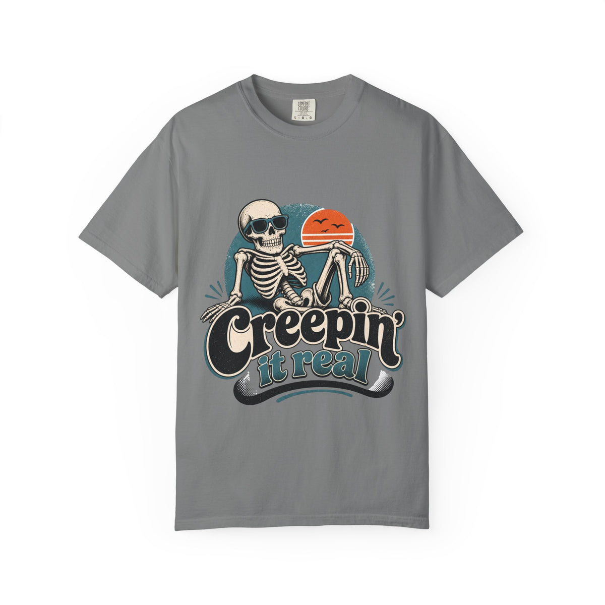 A gray short-sleeve crewneck t-shirt featuring a retro graphic of a skeleton sitting next to an orange sun, with the text 'Creepin' it real' printed below.