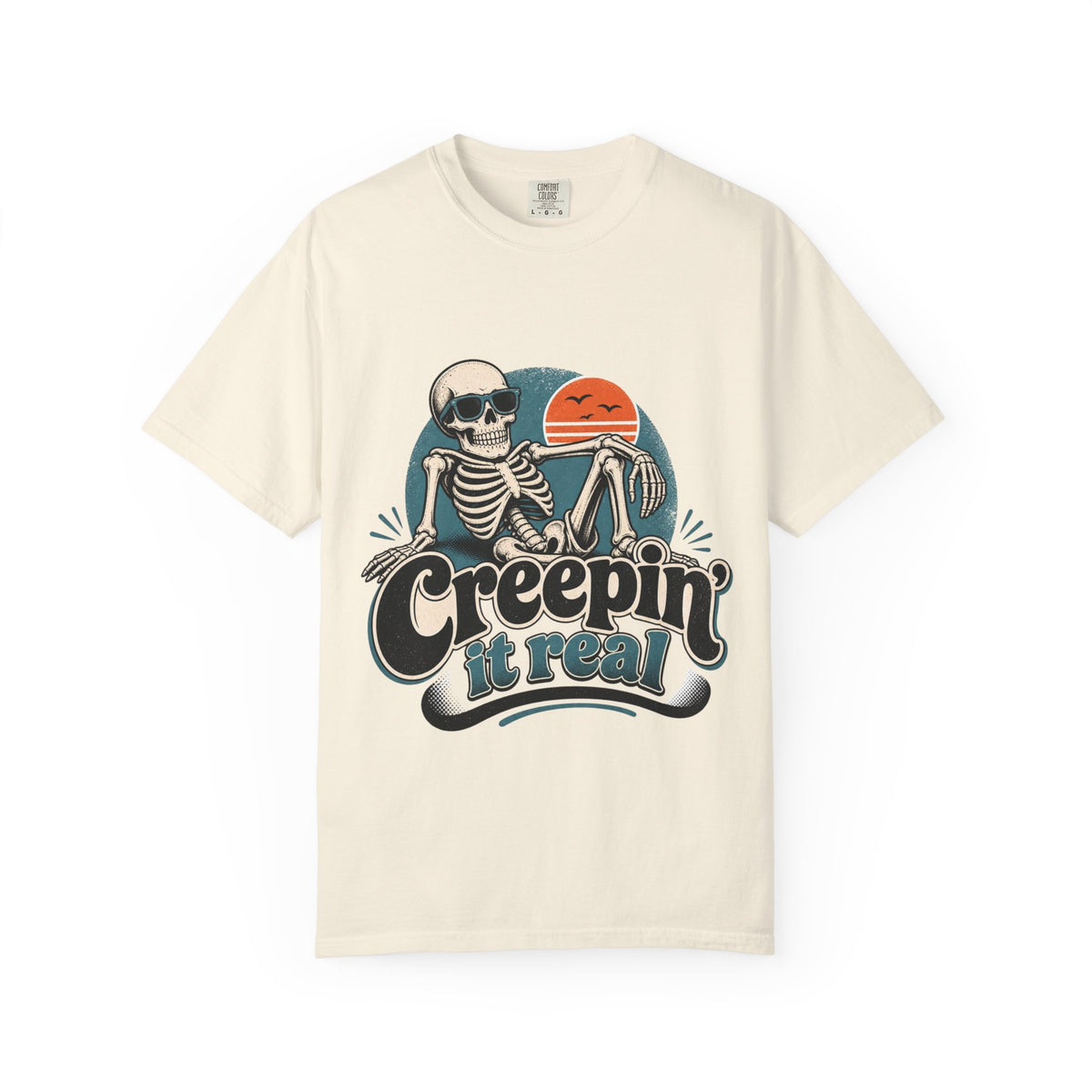 An off short-sleeve crewneck t-shirt featuring a retro graphic of a skeleton sitting next to an orange sun, with the text 'Creepin' it real' printed below.