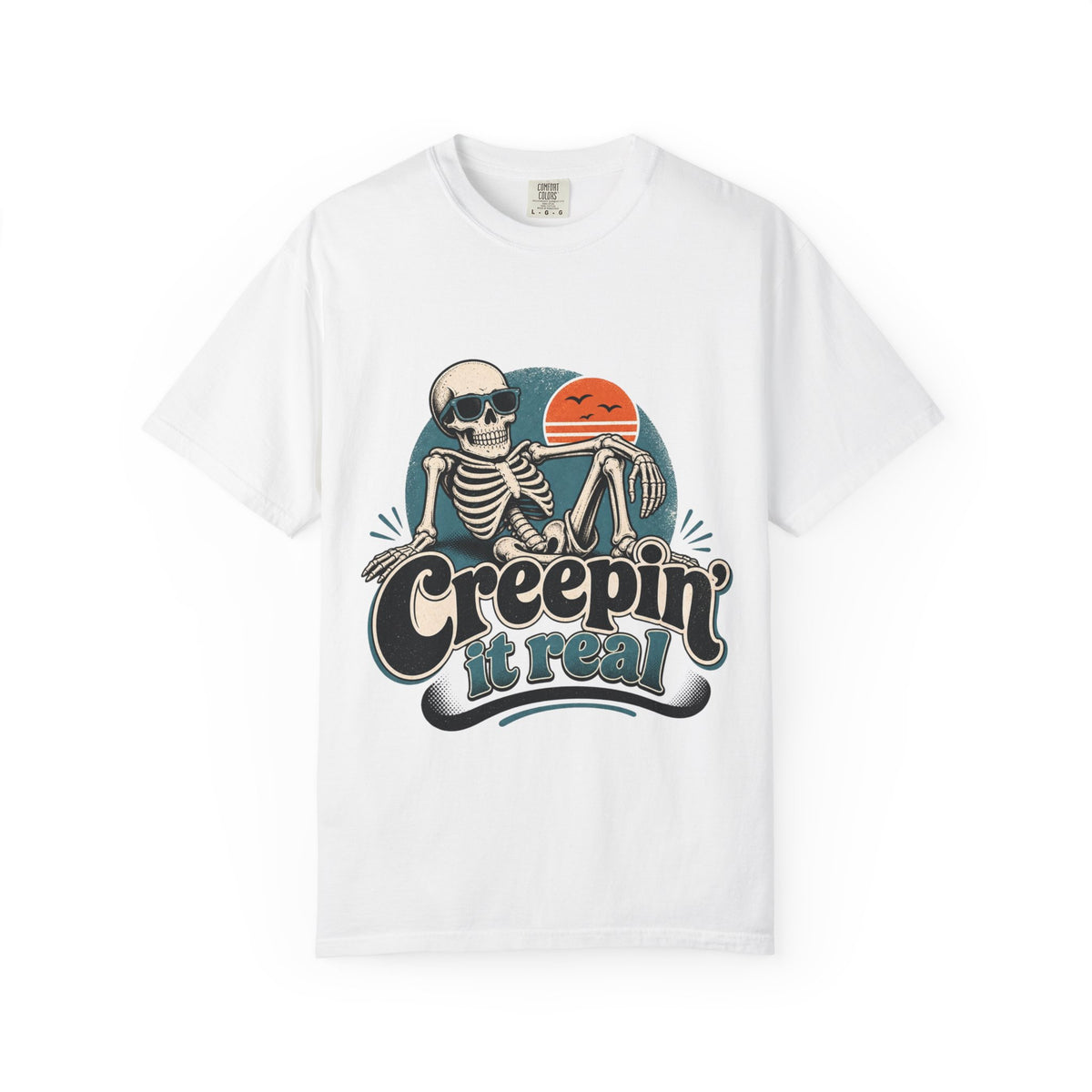 A white short-sleeve crewneck t-shirt featuring a retro graphic of a skeleton sitting next to an orange sun, with the text 'Creepin' it real' printed below.