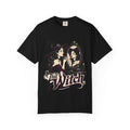A black short-sleeve crewneck t-shirt featuring a graphic print of a witch applying lipstick in front of a mirror, with the text 'That Witch' written below in a stylized font.