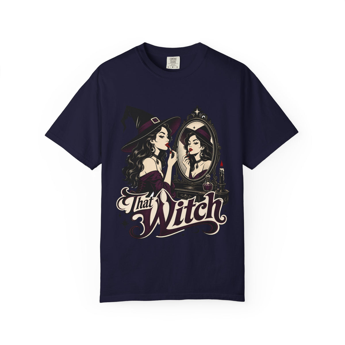 A navy blue short-sleeve crewneck t-shirt featuring a graphic print of a witch applying lipstick in front of a mirror, with the text 'That Witch' written below in a stylized font.