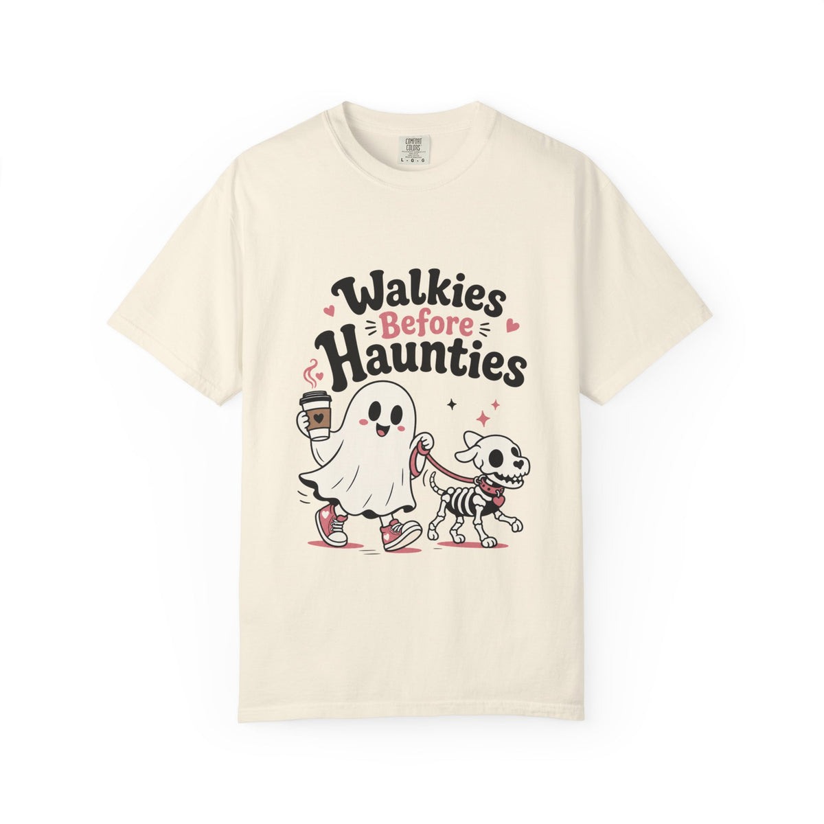 A cream short-sleeve crewneck t-shirt featuring a cute graphic print of a cartoon ghost and a skeleton dog walking together, with the text 'Walkies Before Haunties' above them.