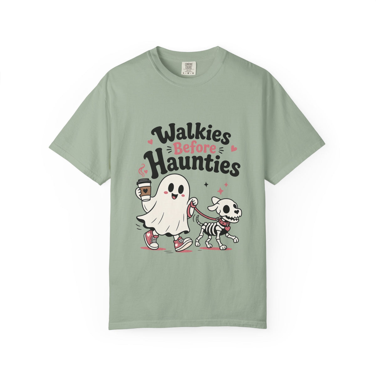 A green short-sleeve crewneck t-shirt featuring a cute graphic print of a cartoon ghost and a skeleton dog walking together, with the text 'Walkies Before Haunties' above them.