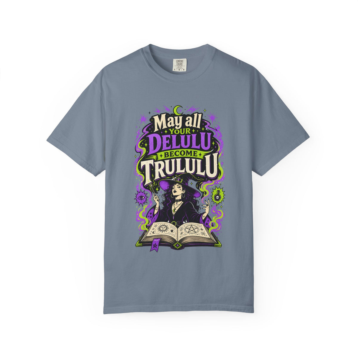 A slate blue short-sleeve crewneck t-shirt featuring a central graphic with the words 'Strange and Ethereal' in a dark gothic font, surrounded by pink and red butterflies, crescent moons, and sparkles.