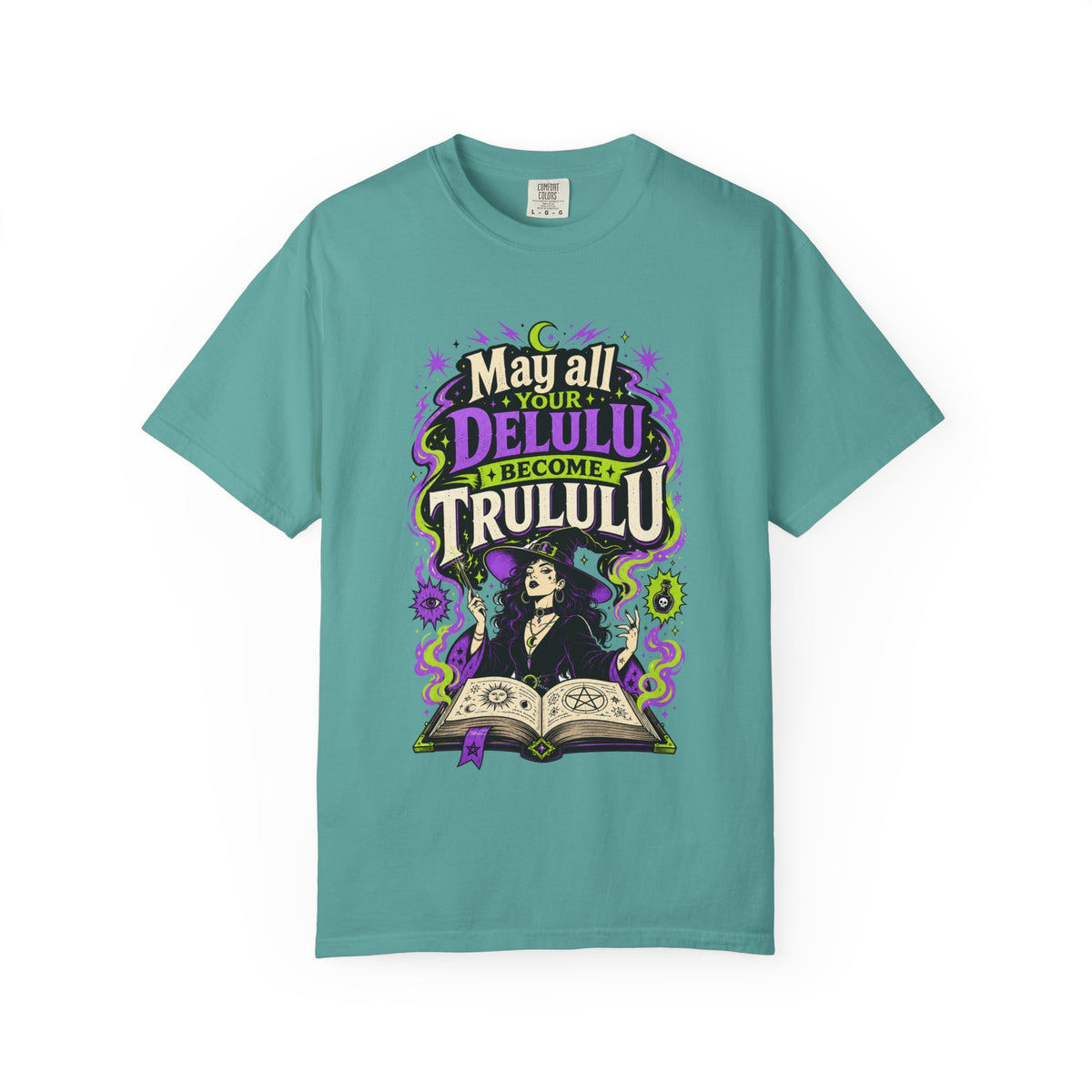 A teal short-sleeve crewneck t-shirt featuring a central graphic with the words 'Strange and Ethereal' in a dark gothic font, surrounded by pink and red butterflies, crescent moons, and sparkles.