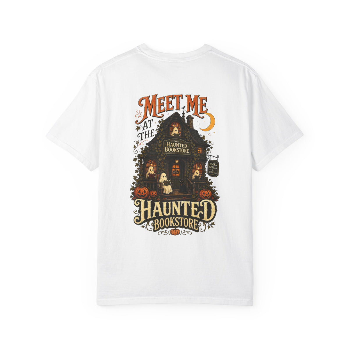 A white short-sleeve crewneck t-shirt featuring a large graphic print on the front. The graphic depicts a spooky haunted bookstore with pumpkins, a ghost, and the text 'MEET ME AT THE HAUNTED BOOKSTORE' in a vintage horror font.