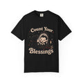 A black short-sleeve crewneck t-shirt featuring a cute cartoon graphic of a vampire smiling at mirror, with the text 'Count Your Blessings' in a peach-colored font.