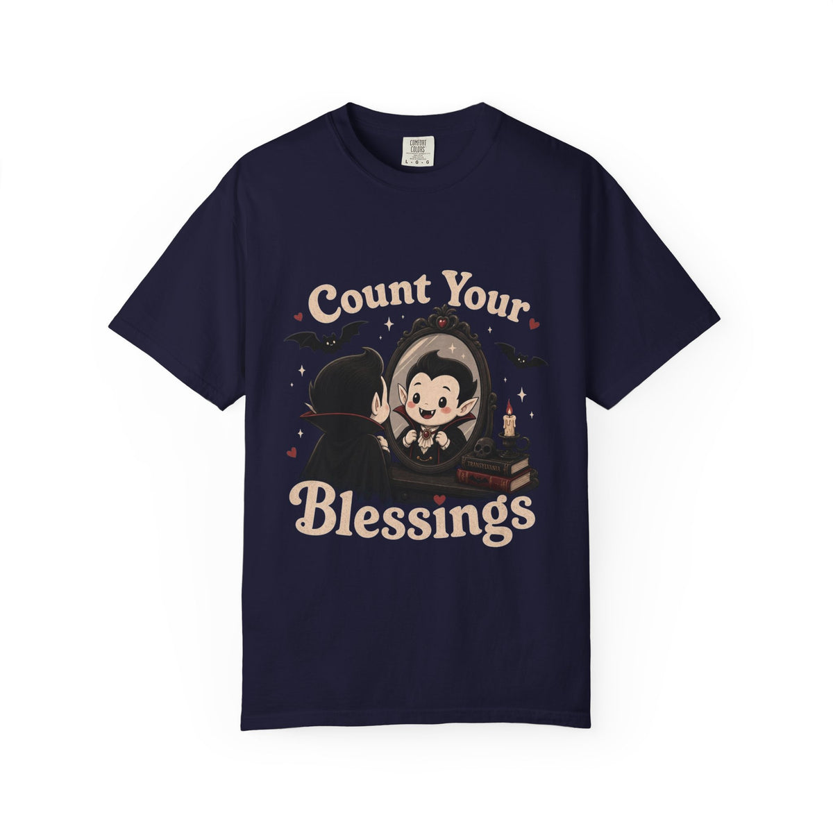 A navy blue short-sleeve crewneck t-shirt featuring a cute cartoon graphic of a vampire smiling at mirror, with the text 'Count Your Blessings' in a peach-colored font.