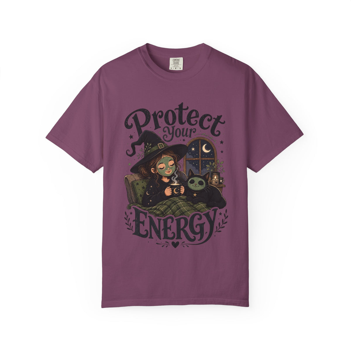 A dark purple short-sleeve crewneck t-shirt featuring a graphic showing a cartoon witch sitting in bed with her cat, both wearing spa face masks, under a window with crescent moon, with the text 'Protect Your Energy' written in a gothic font.