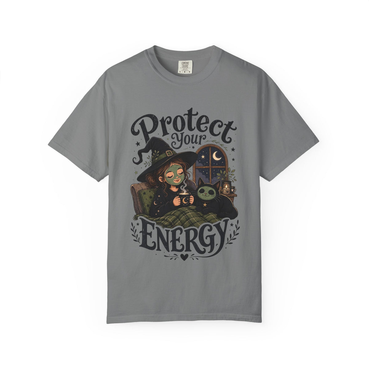 A gray short-sleeve crewneck t-shirt featuring a graphic showing a cartoon witch sitting in bed with her cat, both wearing spa face masks, under a window with crescent moon, with the text 'Protect Your Energy' written in a gothic font.