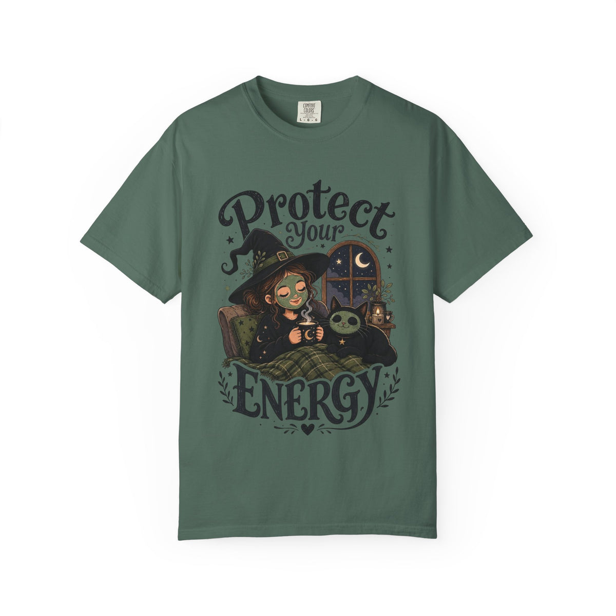 A green short-sleeve crewneck t-shirt featuring a graphic showing a cartoon witch sitting in bed with her cat, both wearing spa face masks, under a window with crescent moon, with the text 'Protect Your Energy' written in a gothic font.